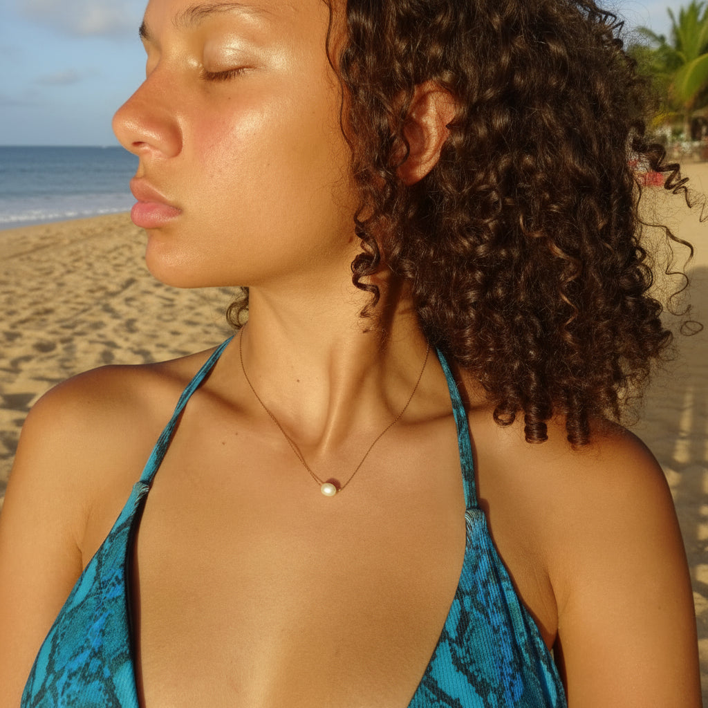 Collier en acier inoxydable 316L doré à chaîne maille bambou ultra fine orné d'une perle d’eau douce blanche porté par une femme.