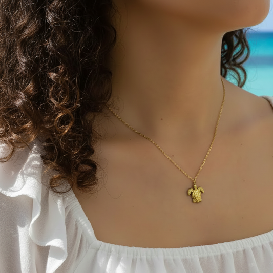 Femme portant un collier pendentif tortue tendance en acier inoxydable 316L doré, avec chaîne maille cubaine, bijou chic et bohème pour femme