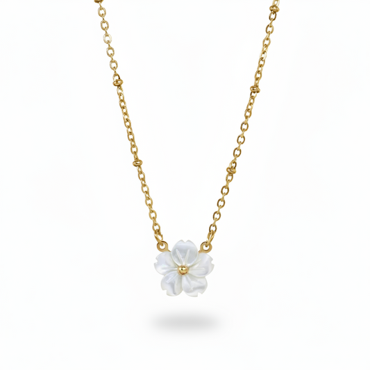 Collier doré en acier inoxydable à fine maille forçat perlée orné d'un pendentif fleur en nacre.