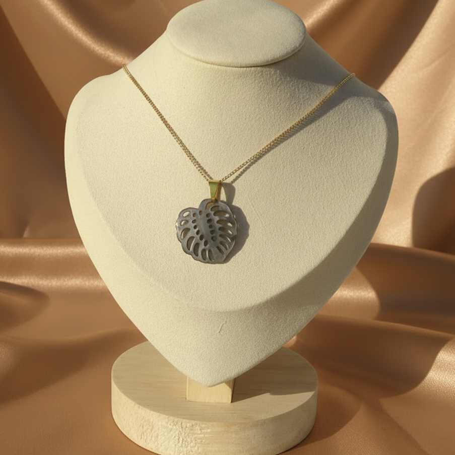 Collier en inox 316L doré à chaîne maille gourmette et pendentif feuille de monstera en nacre grise.