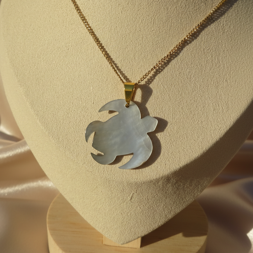 Envers d'un collier en inox 316L doré à chaîne maille gourmette et pendentif tortue des îles en nacre grise, style tropical