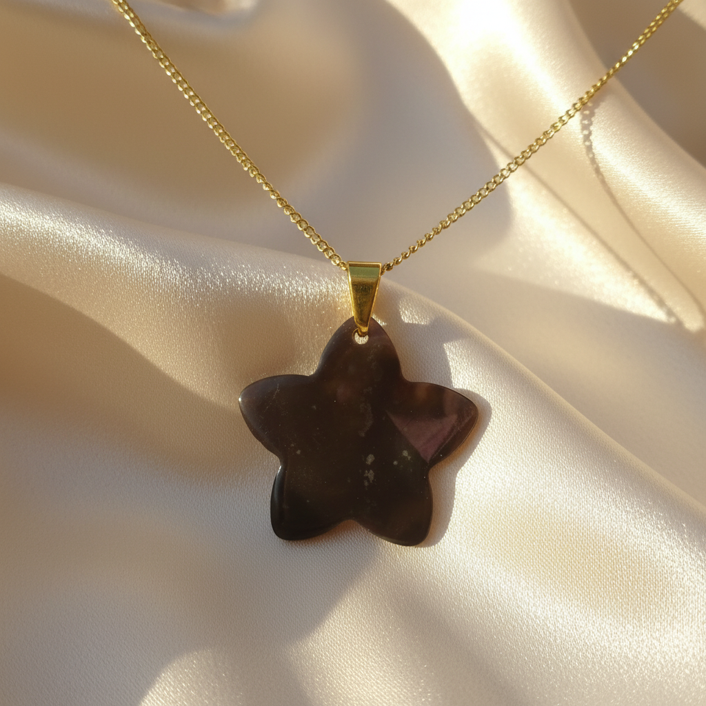 Envers d'un collier en inox 316L doré à chaîne maille gourmette et pendentif fleur de plumeria des îles en nacre grise, style tropical