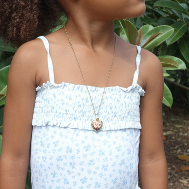 Enfant portant un collier doré en acier inoxydable 316L à maille forçat fine avec pendentif cœur à ouvrir.