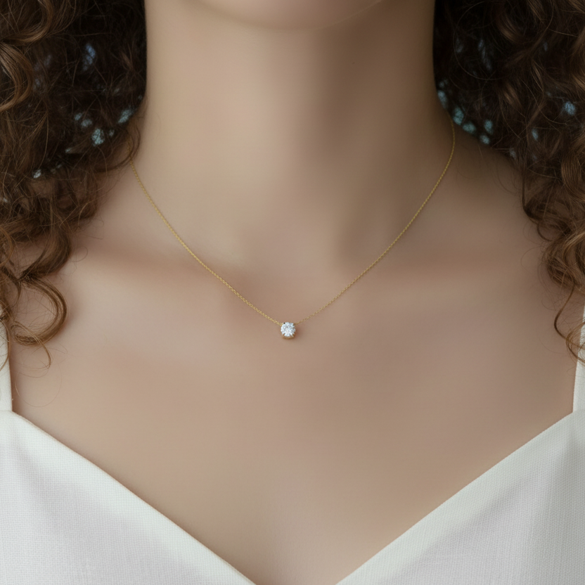 Femme portant un collier en acier inoxydable 316L doré à chaîne ultra fine maille bambou et pendentif petit rond en zircon blanc, bijou délicat, élégant et intemporel