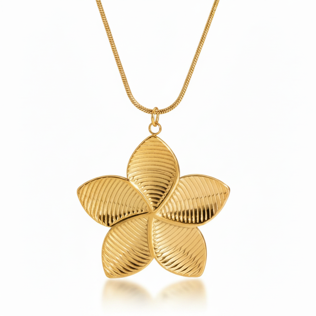 Gros plan sur collier doré en acier inoxydable à chaîne maille serpent orné d'un pendentif grande fleur tropicale de tiaré.