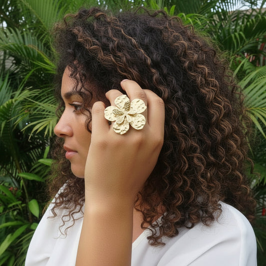 Femme portant une bague dorée ajustable en acier inoxydable, martelée, ornée d’une grande fleur et d’une petite fleur superposées.