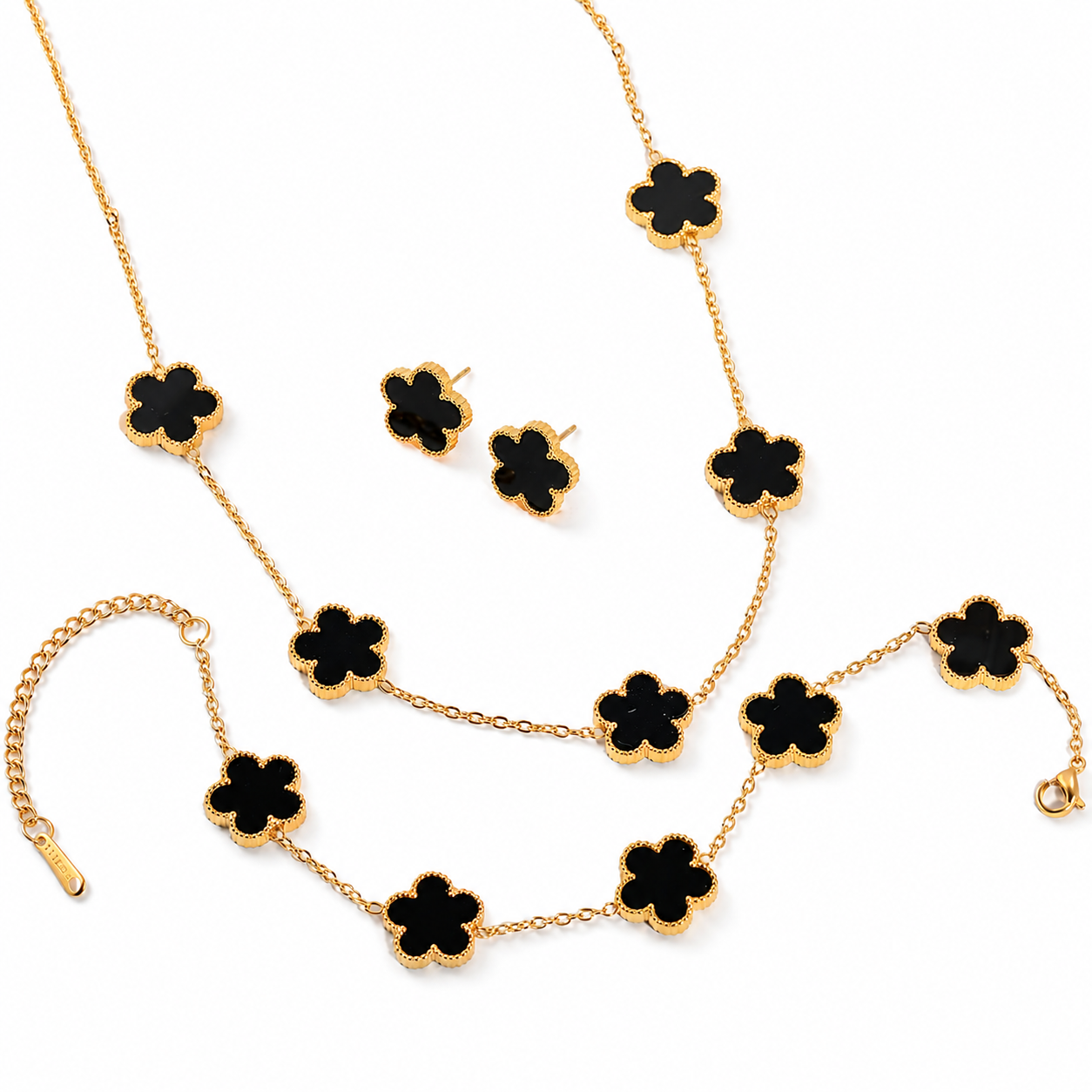 Parure comprenant bracelet, collier et boucles en acier inoxydable 316L doré ornés de petites fleurs en pierre naturelle noire.