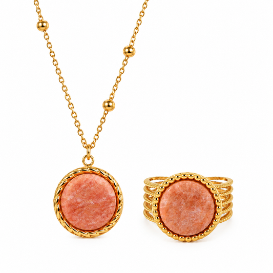 Gros plan sur une parure comprenant un collier et une bague en pierre naturelle pierre de soleil et acier inoxydable 316L doré. 