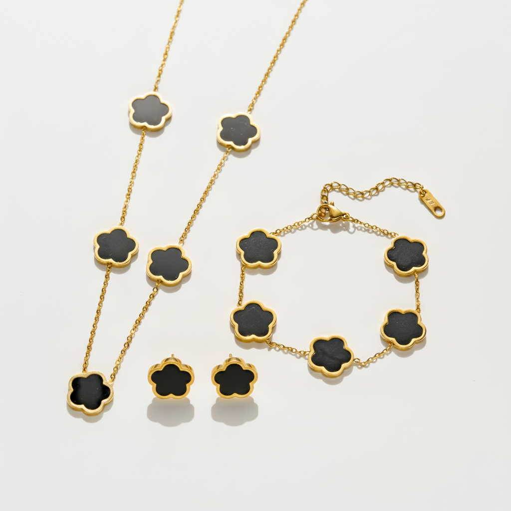 Parure comprenant bracelet, collier et boucles en acier inoxydable 316L doré ornés de petites fleurs en nacre noire.