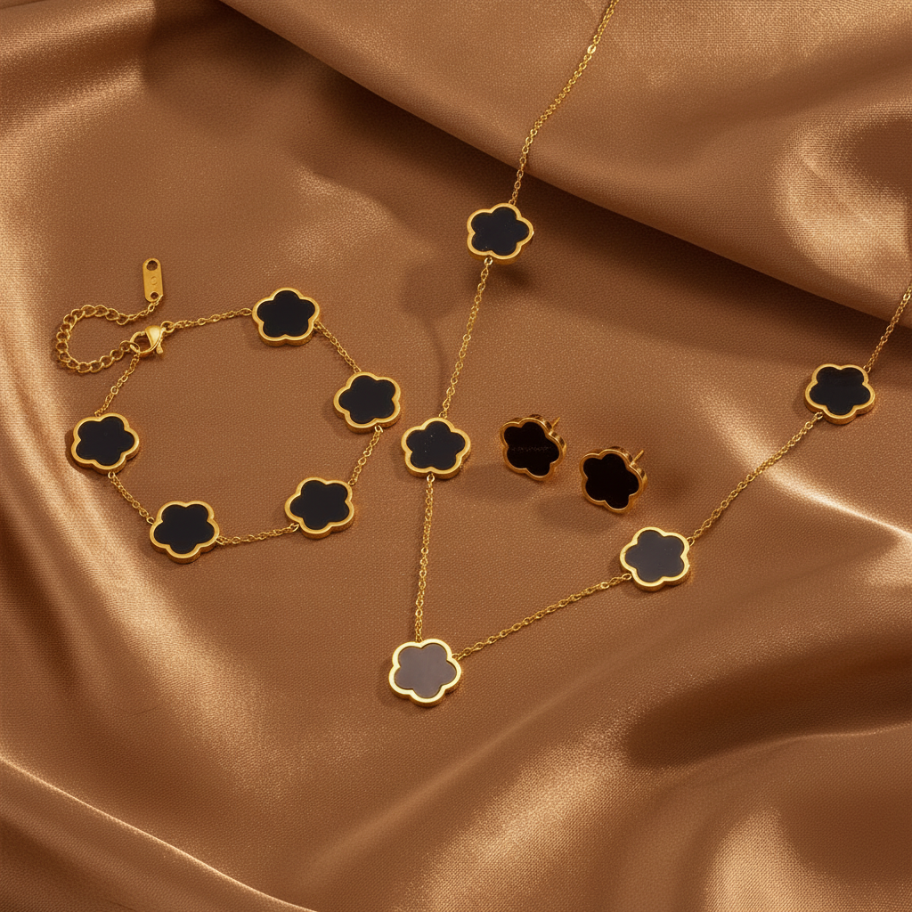 Parure comprenant bracelet, collier et boucles en acier inoxydable 316L doré ornés de fleurs en nacre noire.