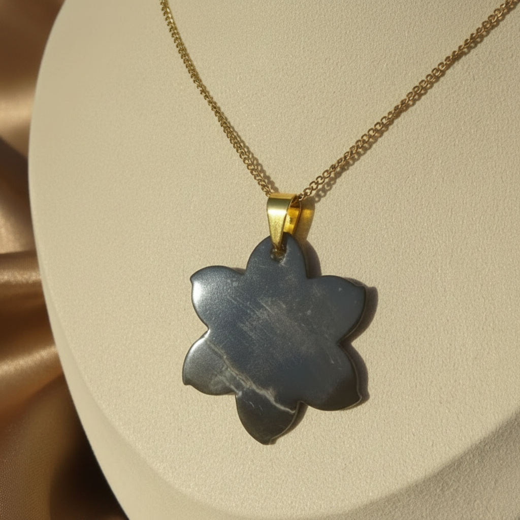 Envers du collier en inox 316L doré à chaîne maille gourmette et pendentif fleur hibiscus en nacre grise.